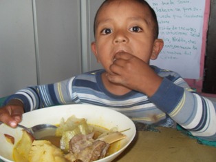 Angelito deleitando se con su comida