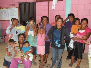 Grupo de mujeres con sus niños-as al final de elección junta directiva del Centro