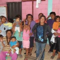 Grupo de mujeres con sus niños-as al final de elección junta directiva del Centro