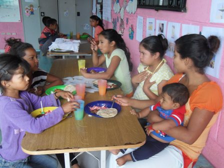 Grupo de niños-as compartiendo su almuerzo