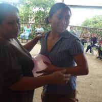 Madres participando concurso de reventar globos en una celebración del Centro