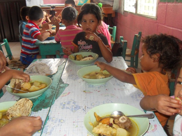 Grupo de niños-as disfrutando su almuerzo