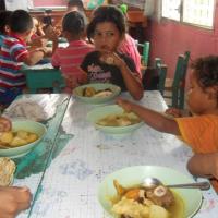 Grupo de niños-as disfrutando su almuerzo