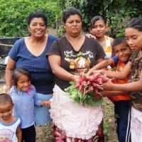 Madres y niñas-os mostrando producción del rábanos del huerto